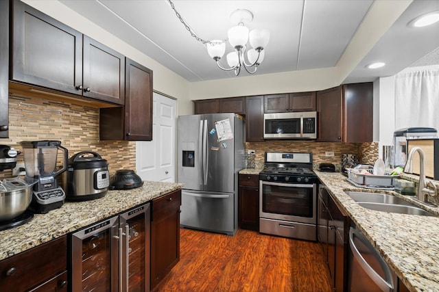 kitchen featuring backsplash, an inviting chandelier, sink, stainless steel appliances, and beverage cooler