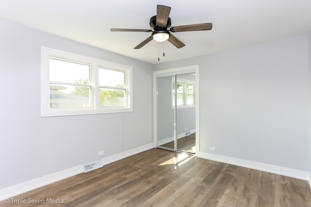 spare room with dark hardwood / wood-style floors and ceiling fan