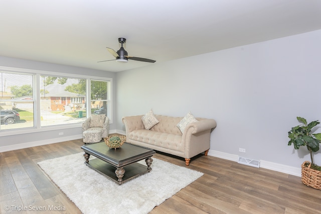 living room featuring wood-type flooring and ceiling fan