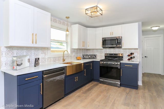 kitchen featuring blue cabinetry, sink, white cabinetry, and stainless steel appliances