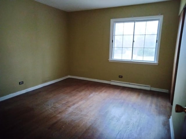 spare room with dark hardwood / wood-style floors and a baseboard radiator