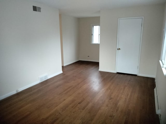 unfurnished room with dark hardwood / wood-style flooring