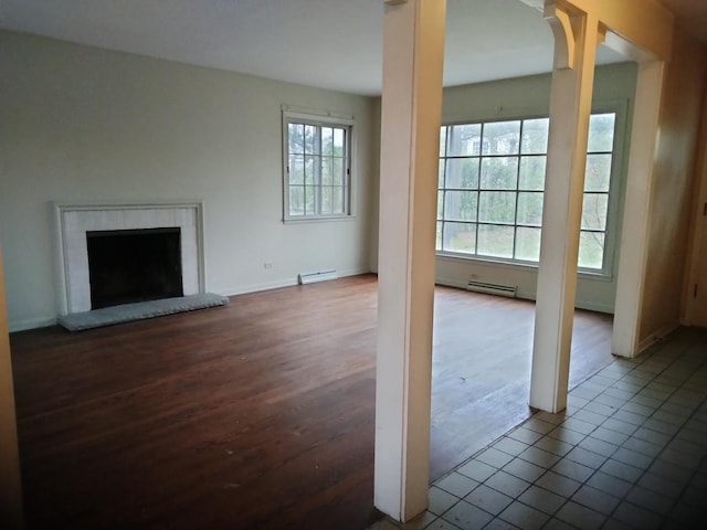 unfurnished living room with a wealth of natural light, tile patterned flooring, and a baseboard radiator