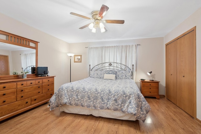 bedroom with light hardwood / wood-style flooring, ceiling fan, and a closet