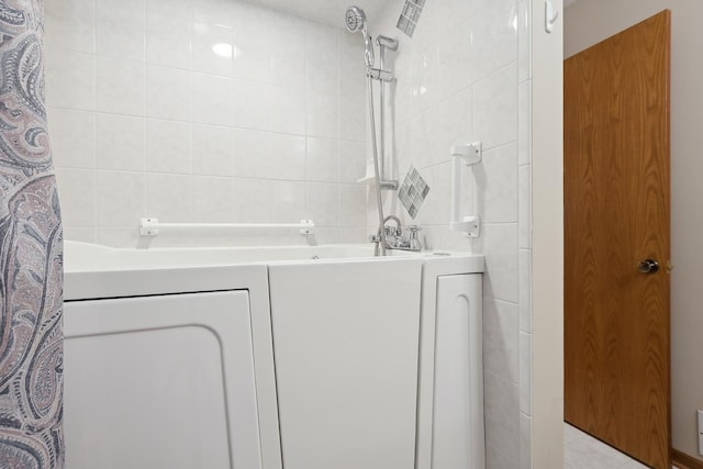 bathroom featuring vanity and tile walls