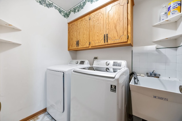 laundry room featuring cabinets, washer and clothes dryer, and sink