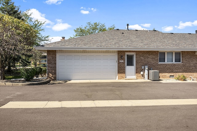 ranch-style house featuring a garage and central AC