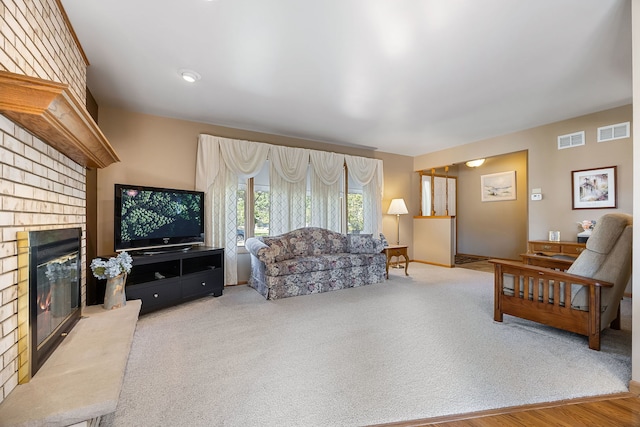 living room featuring a brick fireplace and carpet