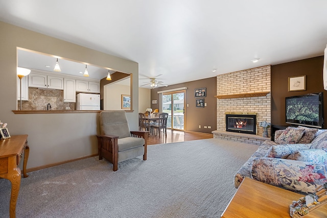 living room with ceiling fan and a fireplace