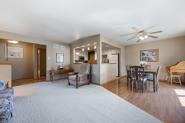 living room with ceiling fan and light hardwood / wood-style floors