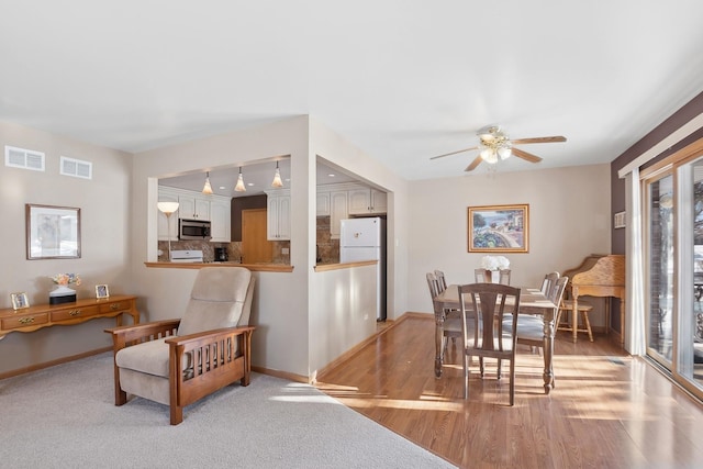 dining space featuring ceiling fan and light wood-type flooring