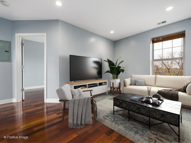 living room with dark hardwood / wood-style flooring and electric panel