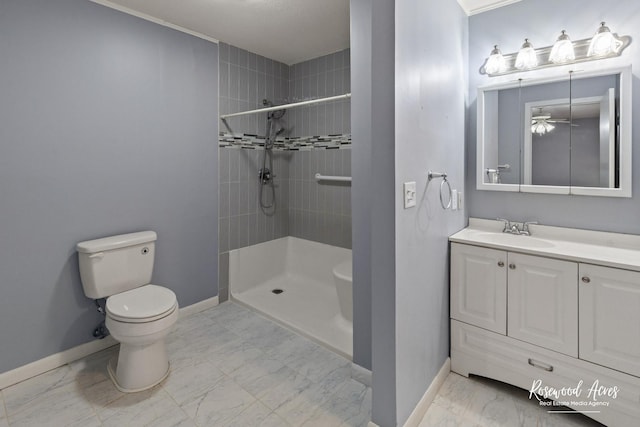 bathroom with toilet, a tile shower, and vanity