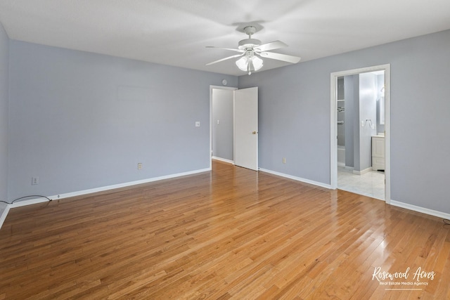 interior space with ceiling fan, light hardwood / wood-style floors, a walk in closet, and connected bathroom