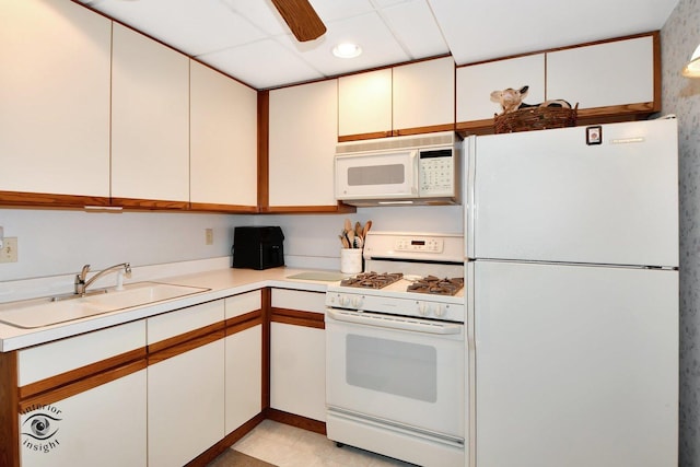 kitchen featuring sink, white appliances, white cabinets, and ceiling fan