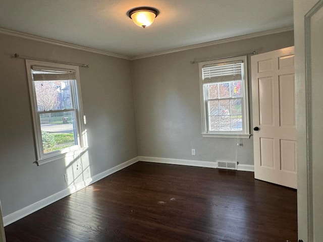 empty room with dark hardwood / wood-style floors, a healthy amount of sunlight, and ornamental molding