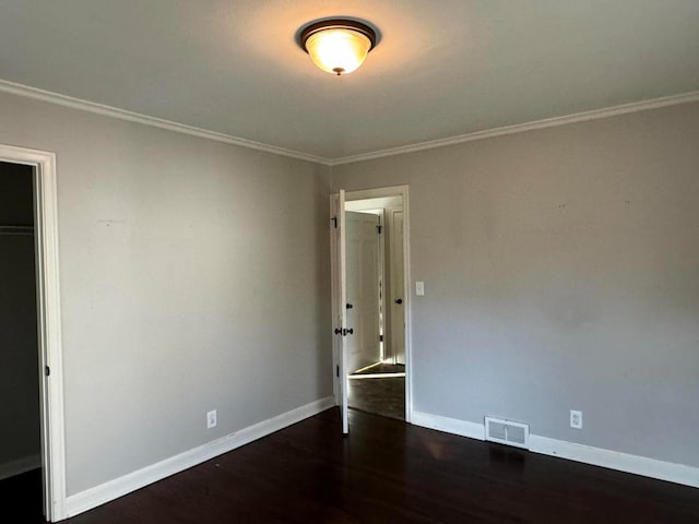 unfurnished bedroom with ornamental molding, a closet, and dark wood-type flooring