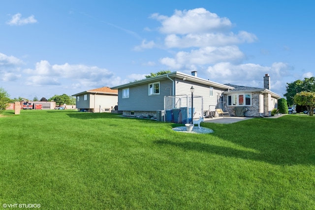 rear view of property featuring a lawn and a patio area