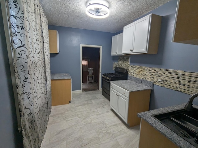 kitchen featuring decorative backsplash, a textured ceiling, sink, white cabinets, and black gas stove