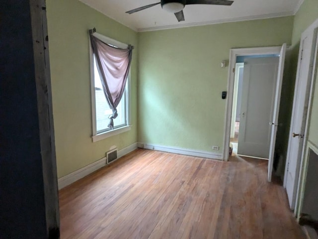 unfurnished bedroom featuring light hardwood / wood-style floors, ceiling fan, and crown molding