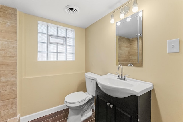 bathroom featuring toilet, vanity, and hardwood / wood-style flooring