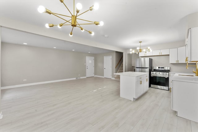 kitchen with a kitchen island, white cabinets, pendant lighting, and appliances with stainless steel finishes