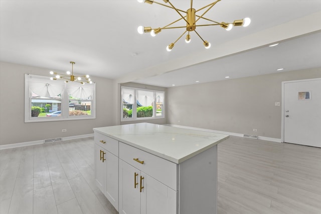 kitchen featuring light hardwood / wood-style flooring, white cabinetry, and a notable chandelier