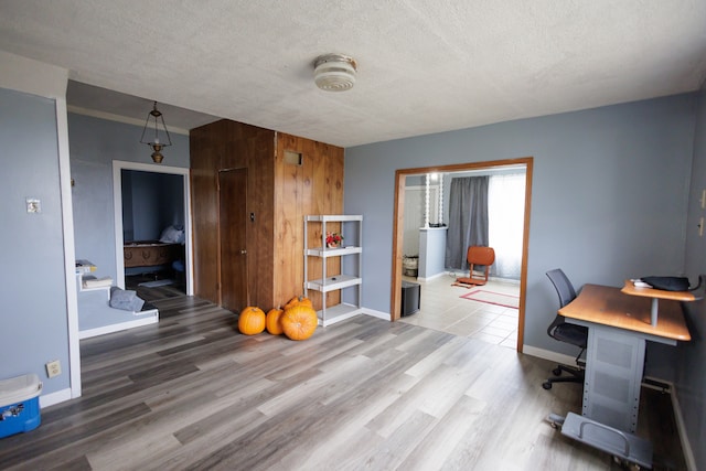 home office with wooden walls, hardwood / wood-style floors, and a textured ceiling