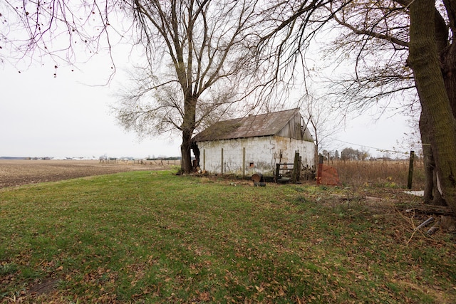 view of yard featuring a rural view and an outdoor structure