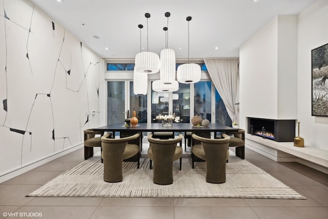 kitchen with tile patterned floors, pendant lighting, a warm lit fireplace, recessed lighting, and a wall of windows