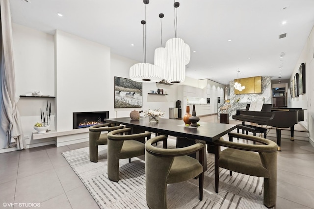 tiled dining space with recessed lighting, visible vents, and a warm lit fireplace