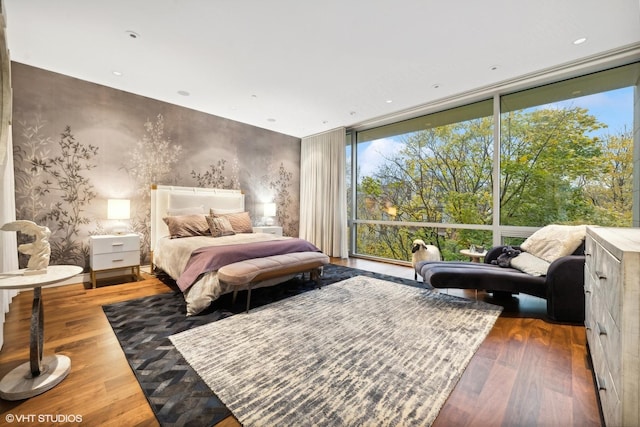 bedroom featuring a wall of windows and wood finished floors