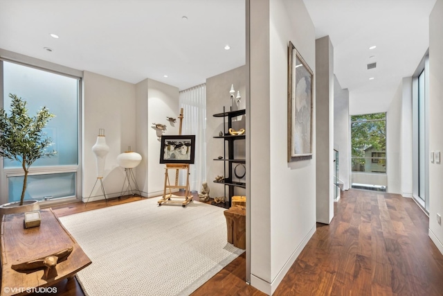 corridor with recessed lighting, wood finished floors, and floor to ceiling windows