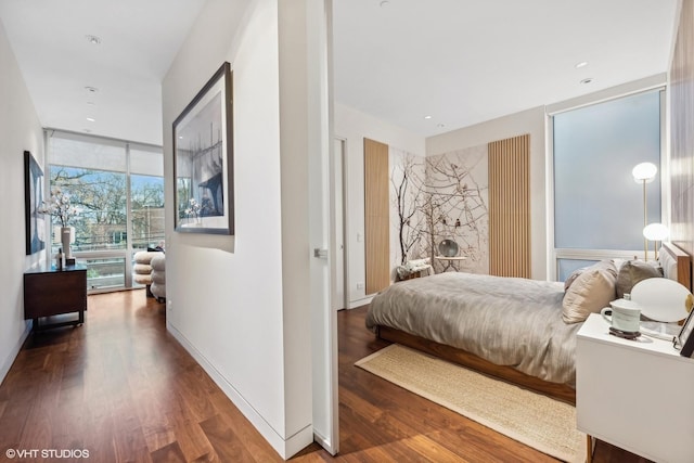 bedroom featuring recessed lighting, wood finished floors, baseboards, and expansive windows