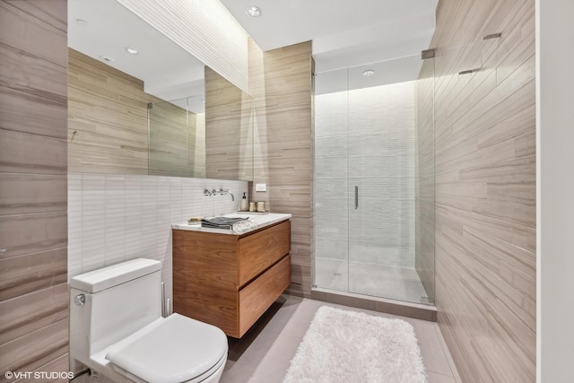 full bathroom featuring vanity, a shower stall, tile walls, toilet, and tile patterned floors