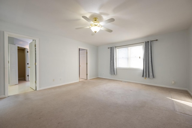 empty room featuring light colored carpet and ceiling fan