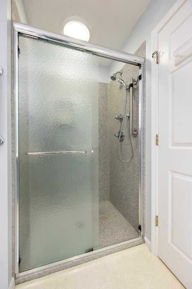 bathroom with a shower with door