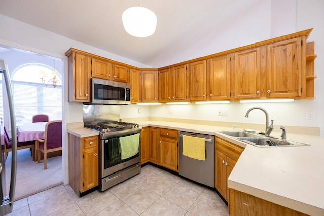 kitchen with sink, stainless steel appliances, light tile patterned floors, and pendant lighting