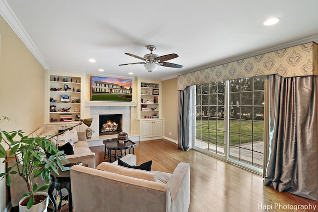 living room with light hardwood / wood-style flooring, ornamental molding, and ceiling fan