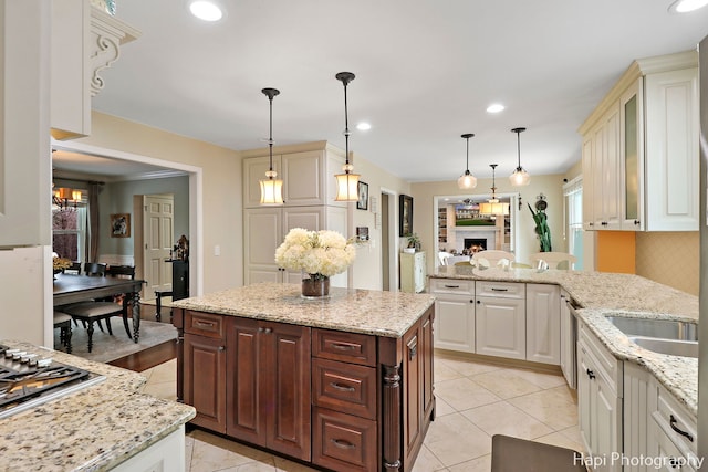 kitchen featuring tasteful backsplash, light stone countertops, pendant lighting, and appliances with stainless steel finishes