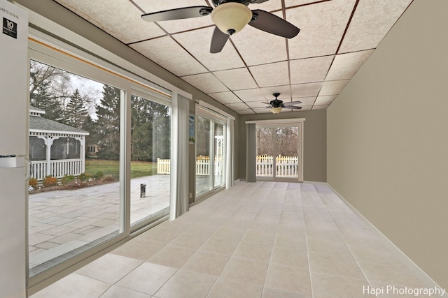 unfurnished sunroom with a paneled ceiling and ceiling fan