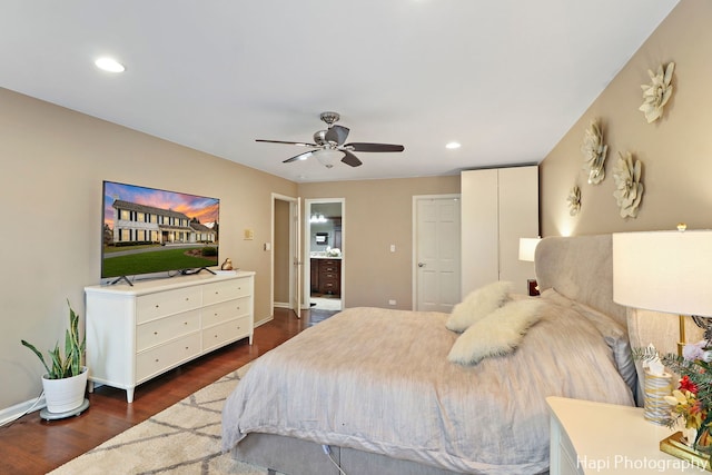 bedroom featuring ceiling fan, dark wood-type flooring, and ensuite bath