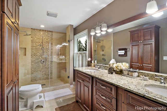 bathroom with toilet, vanity, tile patterned floors, and walk in shower