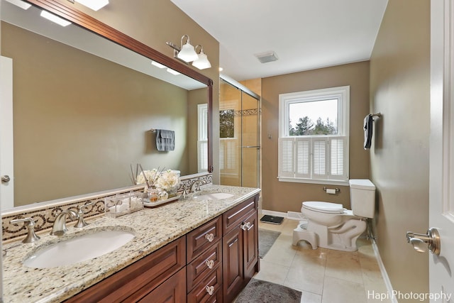 bathroom featuring tile patterned flooring, vanity, a shower with shower door, and toilet