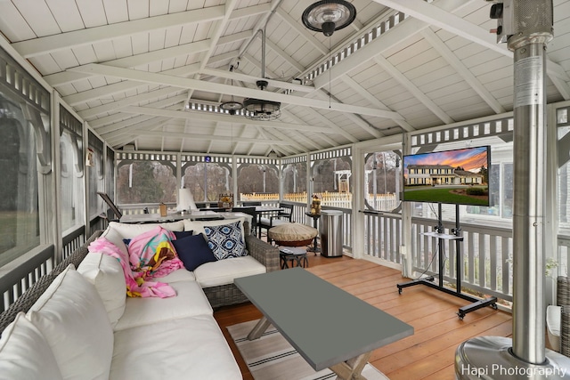 sunroom / solarium featuring lofted ceiling with beams