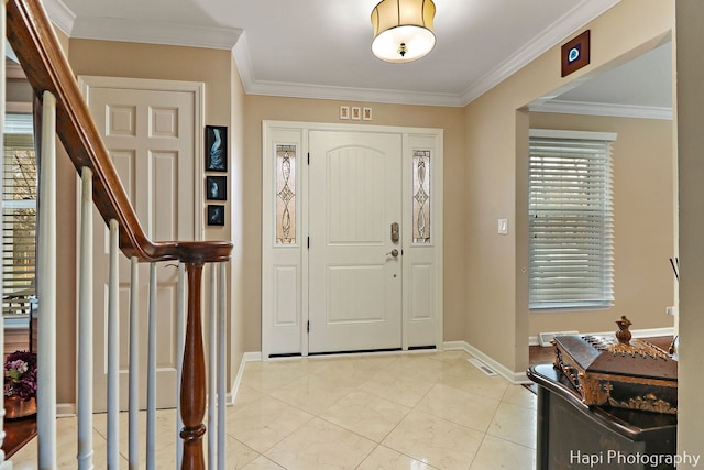 foyer with crown molding and light tile patterned floors