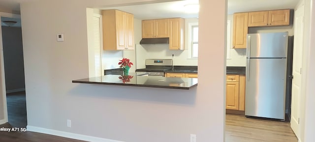 kitchen featuring kitchen peninsula, stove, light brown cabinets, light hardwood / wood-style floors, and stainless steel refrigerator