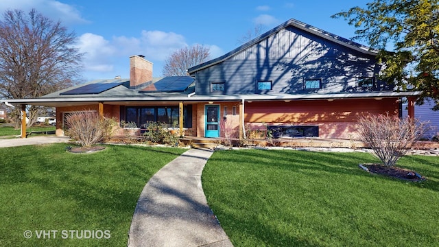 view of front of home with solar panels and a front yard