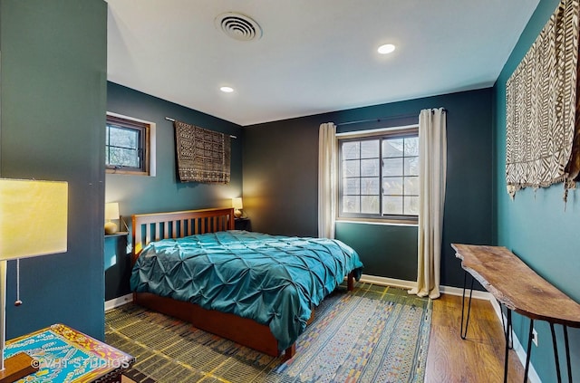 bedroom featuring wood-type flooring and multiple windows