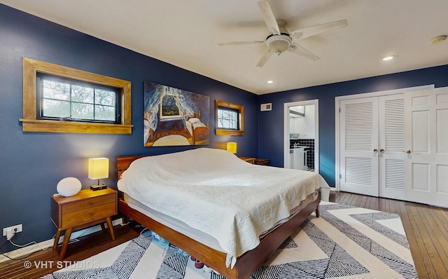 bedroom featuring ceiling fan, wood-type flooring, and multiple windows